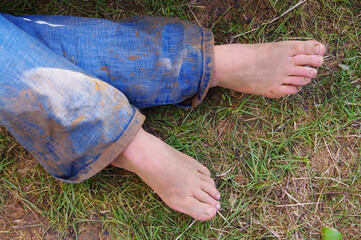 A person's feet are on the grass with their pants on - 748986089