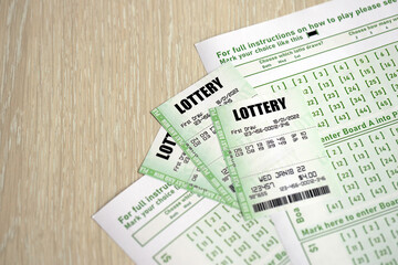 Green lottery tickets and blank bills with numbers for playing lottery close up