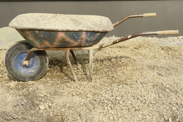 A wheelbarrow is sitting on a pile of dirt - 748988641