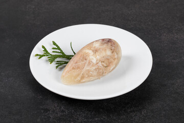 Cold appetizer. Chicken jellied meat in the shape of a quenelle. Darak gray background. On a plate....