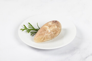 Aspic. Jellied meat in the shape of a quenelle. On a plate. Close up