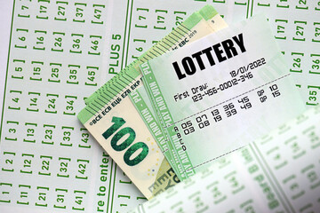 Green lottery tickets and euro money bills on blank with numbers for playing lottery close up