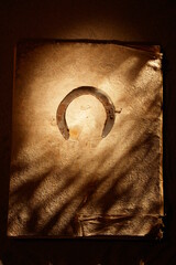 A worn leather bound book with a horse shoe on the cover - 748990641