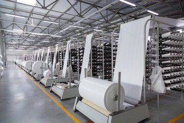 Factory. Interior of a factory workshop for the production of polypropylene bags. Racks with rolls...