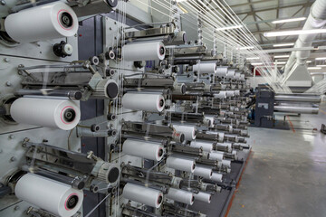 Factory equipment in perspective. Rows with coils of polypropylene threads for weaving cloth....