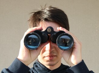 Teenager watching around with binoculars