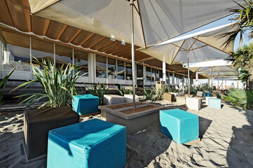 Beach with chaise lounges, umbrellas, palm trees and the sea - 749014279