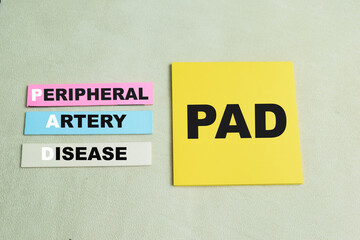 Fototapeta premium Concept of PAD - Peripheral Artery Disease write on sticky notes isolated on Wooden Table.