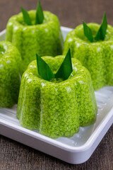 pudding lumut or moss pudding served on a white plate with pandan leaves on top. Very fresh and healthy food