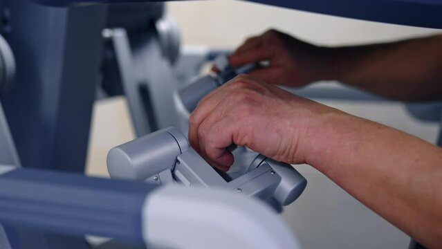 Doctor hands remoting surgery robot. Futuristic operating close up view perfoming.