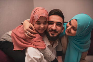 Happy Muslim Family at home. Smiling arabic mom, dad and daughter having fun together