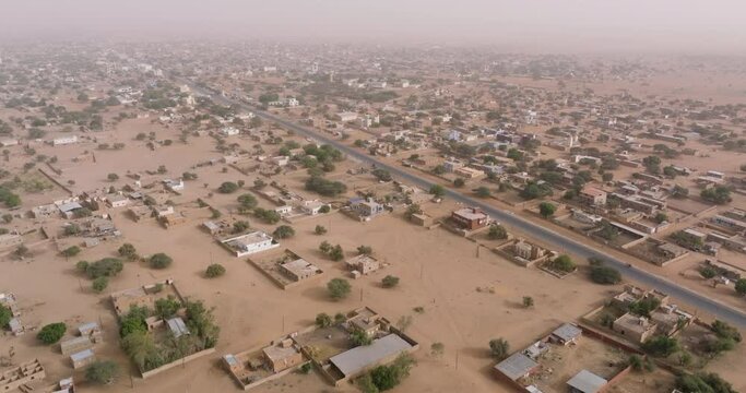Aerial fly over.  A typical farming village in the barren landscape of the Sahel region, Sahara Desert, Senegal. Drought, Climate Change, Desertification