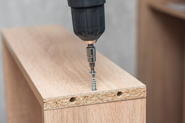 Assembling furniture, tightening confirmat with a screwdriver