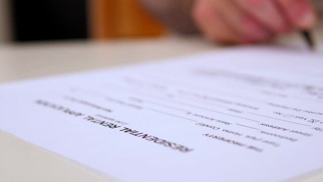 hand of young man enters data in the residential rental application in the US