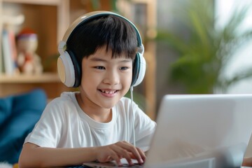 A young boy with a calm expression using a laptop and headphones, engaged in a learning or entertainment activity