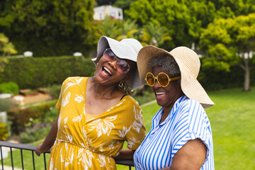 Senior African American woman and senior biracial woman share a joyful moment outdoors