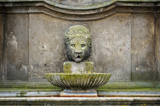 Lion head shaped fountain in the garden of the palace made of stone