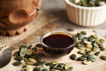 Pumpkin seed oil in a glass bowl on a wooden table