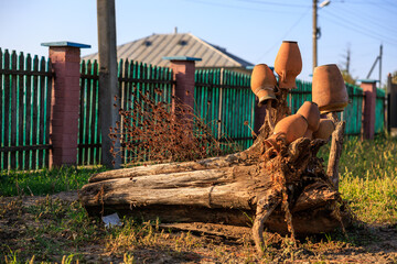 Clay pots on a stump, rural decoration. Background with selective focus and copy space