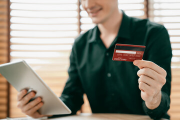 Young man using tablet with credit card for internet banking, online shopping E commerce by online...