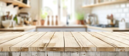 A white plank wooden table top sits in front of a kitchen, offering a blank canvas for display or design purposes. The kitchen in the background is blurred, providing a homey backdrop for the scene.