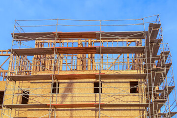 Building wooden framework with lumber scaffolding and blue sky