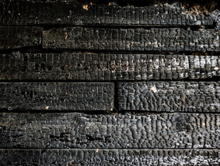 Burnt charred wooden plank surface after fire
