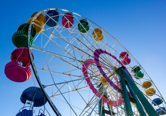 Ferris wheel with colored booths against the sky. Attraction in the park, Ferris wheel.