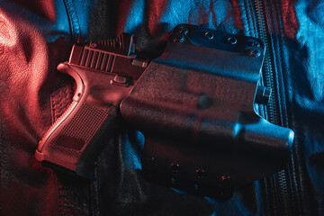 A pistol with a flashlight and a red dot sight in a holster, close-up photo.