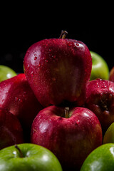 Red and green apples on a black background