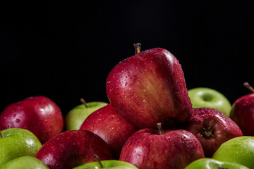 Red and green apples on a black background
