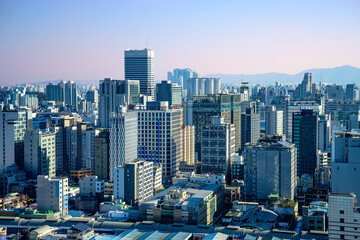 Fototapeta na wymiar Seoul City Skyline with modern buildings and traditional slated houses in downtown with a view Bukhansan Mountains in the distance in South Korea