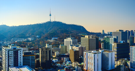 Obraz premium Seoul City Downtown Skyline with modern skyscrapers, buildings under construction, traditional houses, Namsan Tower, and Namsan Mountain National Park area in South Korea