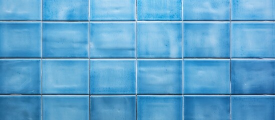 This close-up showcases the intricate details of a blue tiled wall, commonly found in bathrooms, pools, and kitchens. The square tiles are old yet vibrant, adding a pop of color to the interior space.