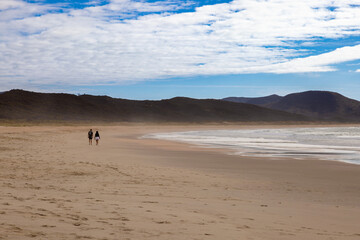 Lone couple walking on a deserted beach, Spirits Bay, New Zealand