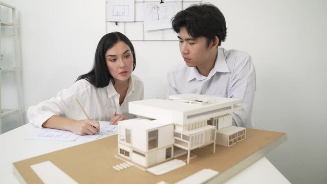 Professional smart cooperate architect engineer team checking house structure at modern office with blueprint while young beautiful project manager taking a note. Creative design concept. Immaculate..