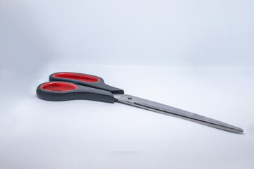 red plastic scissors on white background