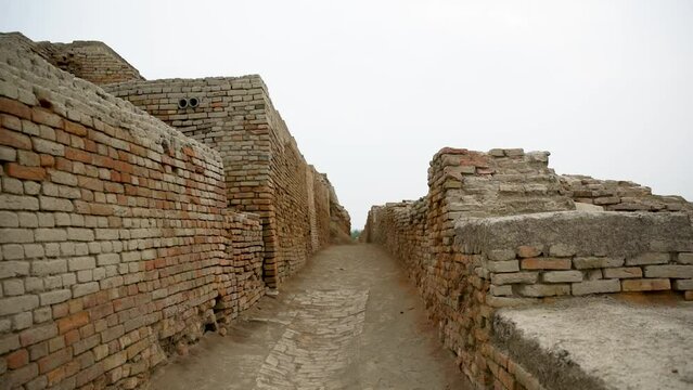an expansive archaeological site featuring the ruins of an ancient civilization. The remnants of brick structures stand testament to the complex architecture and urban planning of Mohenjo Daro.   