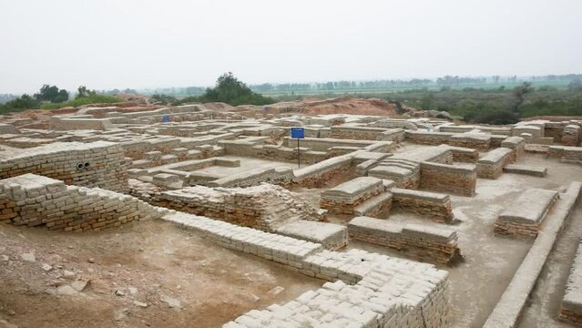 an expansive archaeological site featuring the ruins of an ancient civilization. The remnants of brick structures stand testament to the complex architecture and urban planning of Mohenjo Daro.   