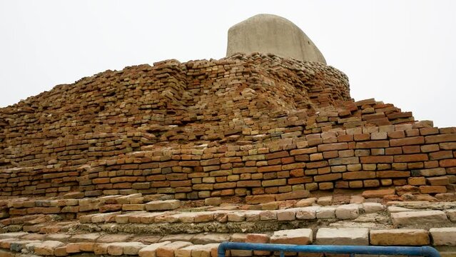 an expansive archaeological site featuring the ruins of an ancient civilization. The remnants of brick structures stand testament to the complex architecture and urban planning of Mohenjo Daro.   