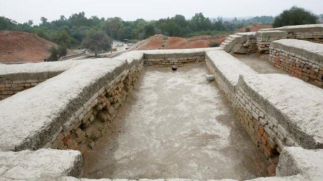 an expansive archaeological site featuring the ruins of an ancient civilization. The remnants of brick structures stand testament to the complex architecture and urban planning of Mohenjo Daro.   