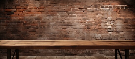 An empty wooden table is positioned in front of a weathered brick wall, creating a rustic backdrop...