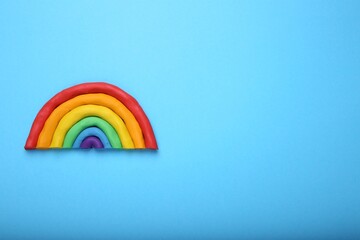 Beautiful rainbow made of plasticine on light blue background, top view. Space for text