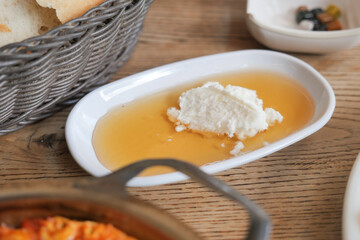 butter cream and honey in a bowl on table .