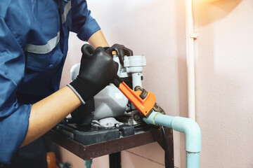 Technician plumber using a wrench to repair a water pump pipe. Concept of maintenance, fix water plumbing leaks drop or house bathroom service or cleaning clogged pipes is dirty or rusty. - obrazy, fototapety, plakaty