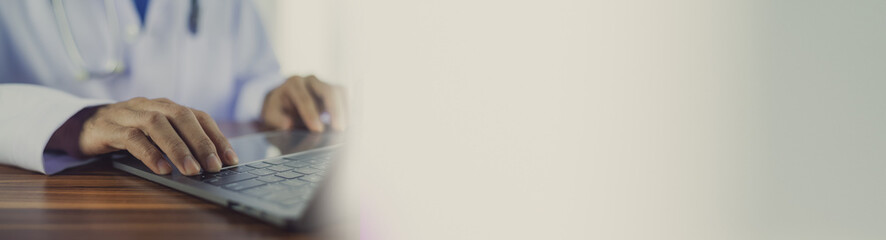 Doctor using a computer in office copy spec background