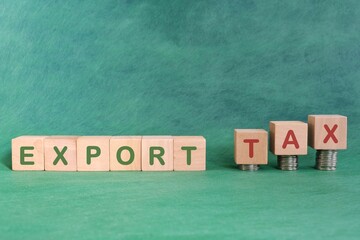 Export tax concept. Word in wooden blocks with increasing stack of coins.	