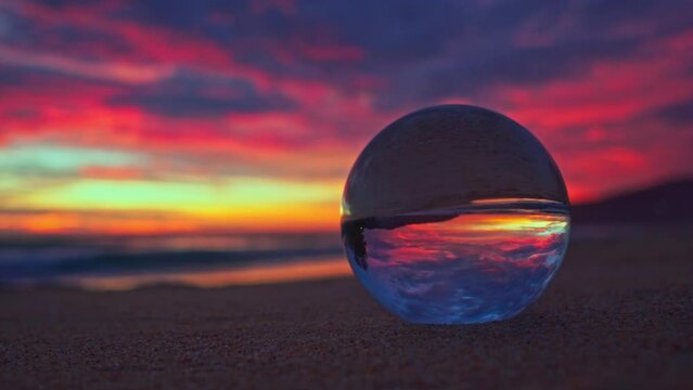 Amazing view of colorful cloud in sky of sunset inside crystal ball. .The natural view of the sea and sky in beautiful sunset on Phuket beach. .AN image for a unique and creative travel.