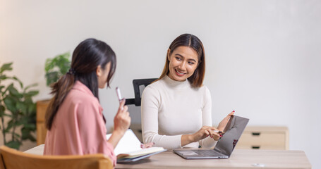 Two young asian happy business women working together for analyze planning and financial statistics and investment market  in home office space