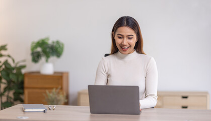 Beautiful young asian business woman working on her laptop in her home office.